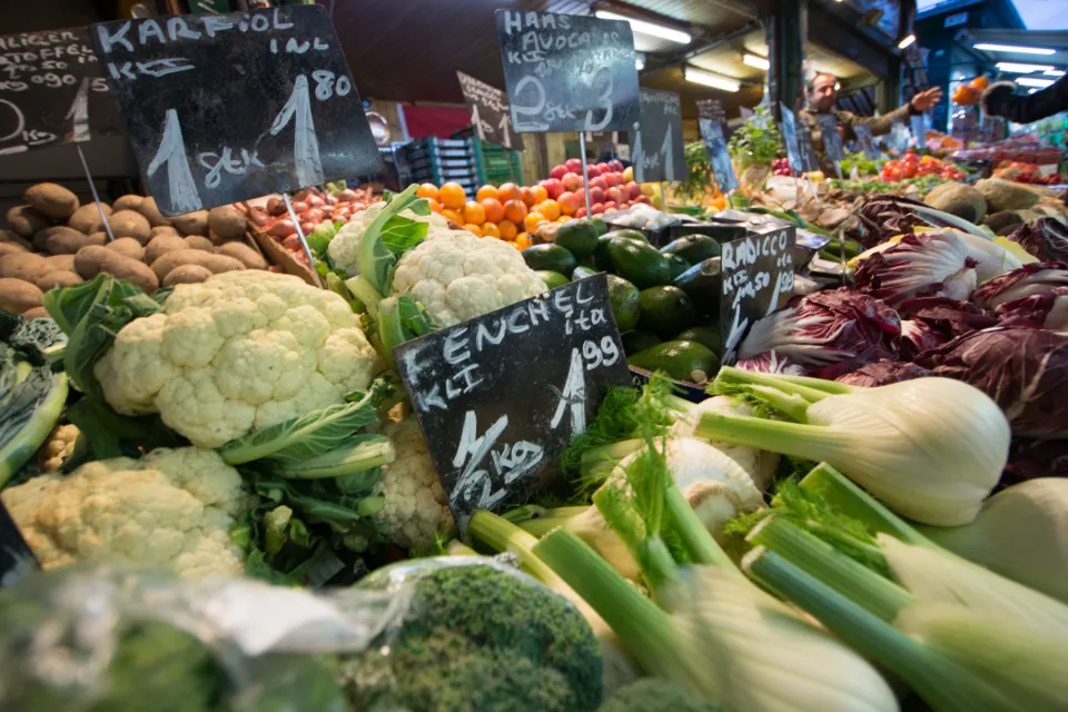Frisches Gemüse an einem Marktstand mit handgeschriebenen Preistafeln